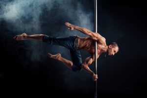 Fit Guy in Black Pants on a Pole