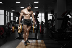 Muscular Guy in Black Shorts Holding Two Yellow Weights