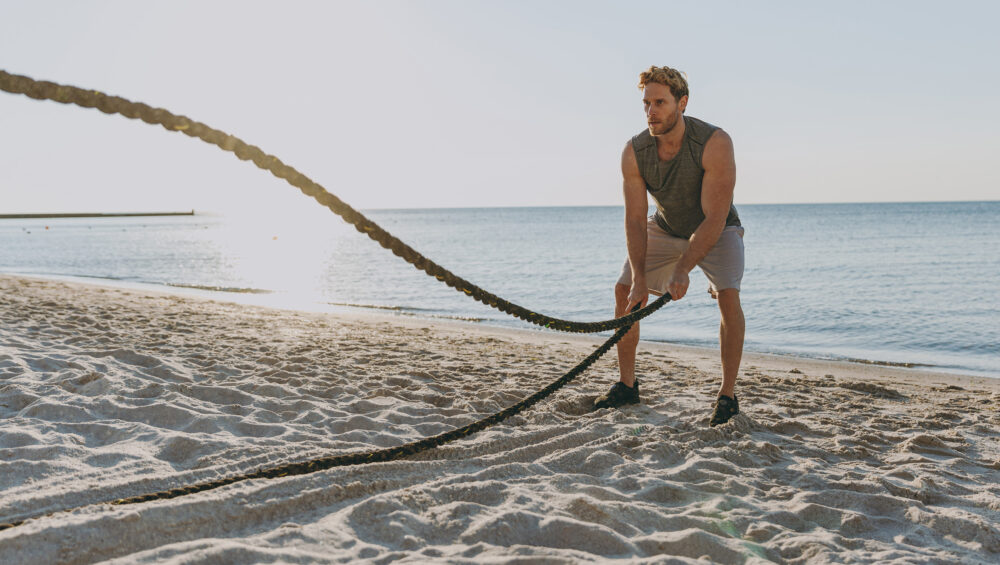 Fitness Guy Doing Alternate Ropes At The Beach