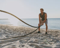Fitness Guy Doing Alternate Ropes At The Beach